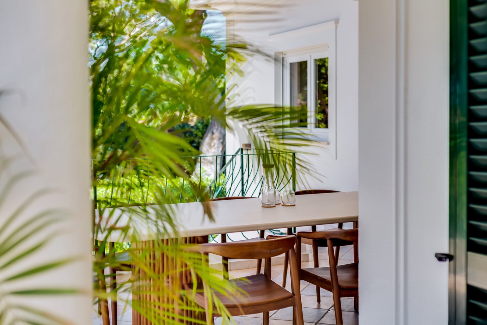 Balcony dining table seen through palm fronds