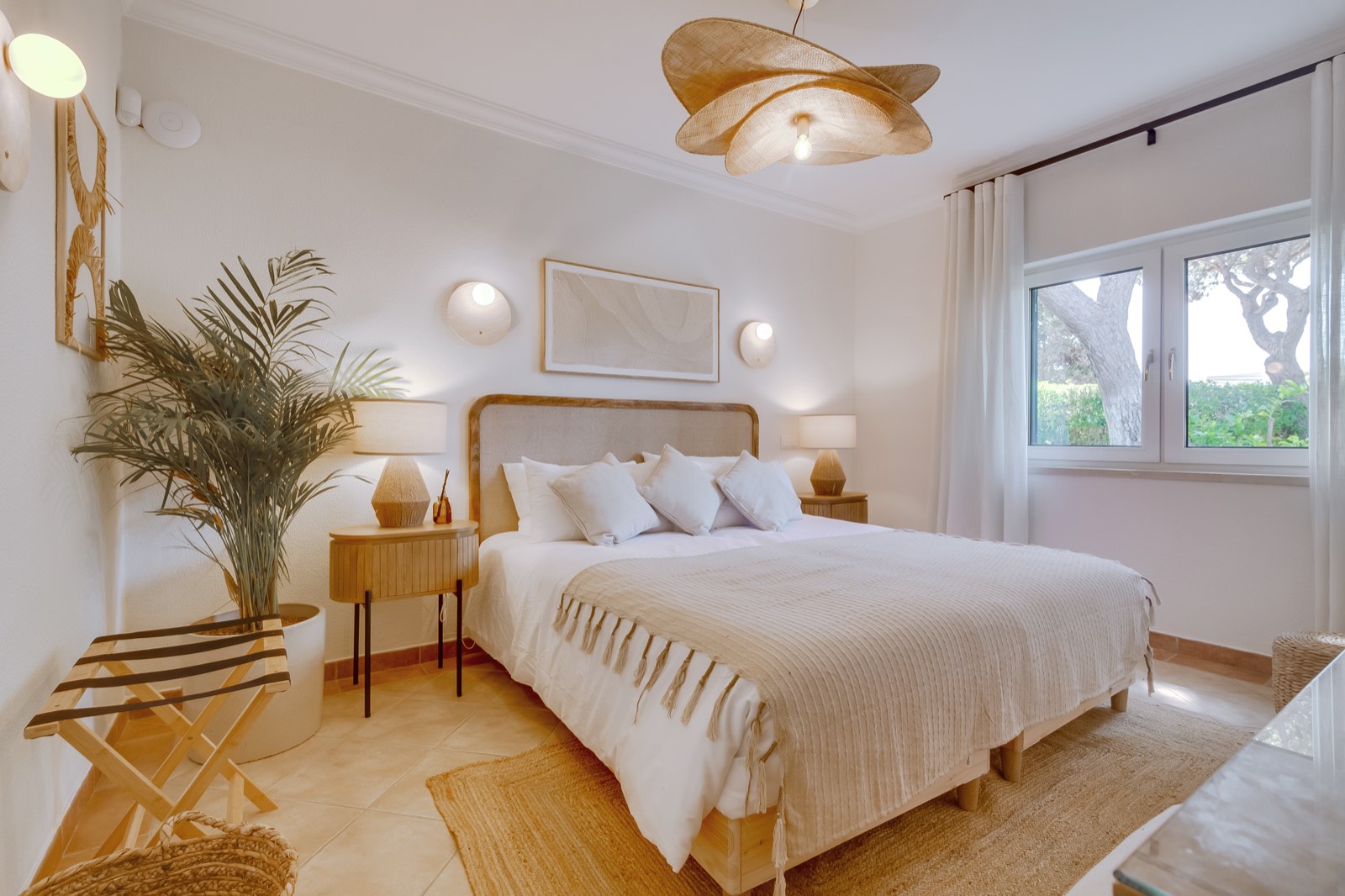 Warm-toned bedroom with straw pendant and garden window