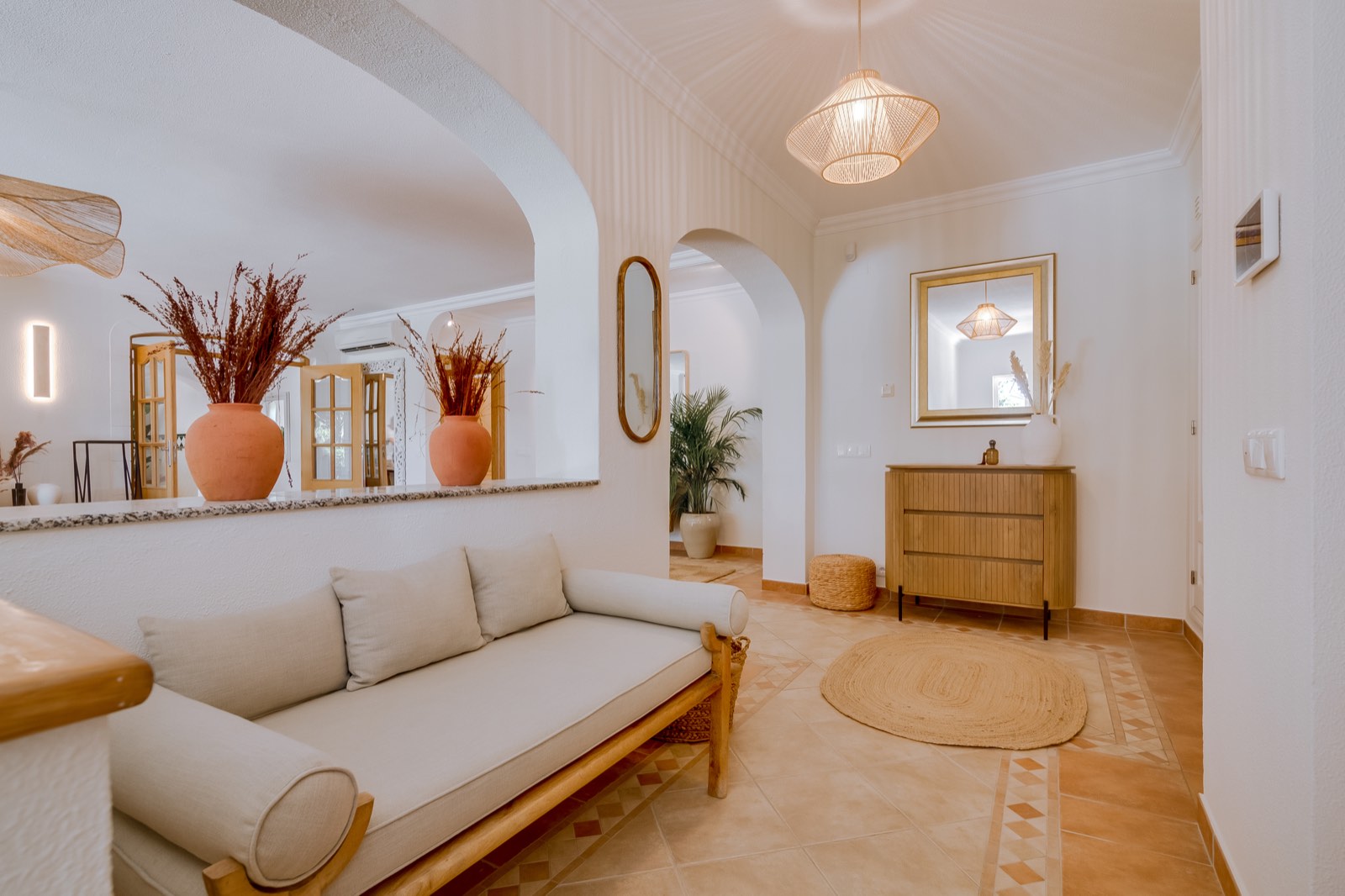 Quiet seating nook with daybed, arches and terracotta urns