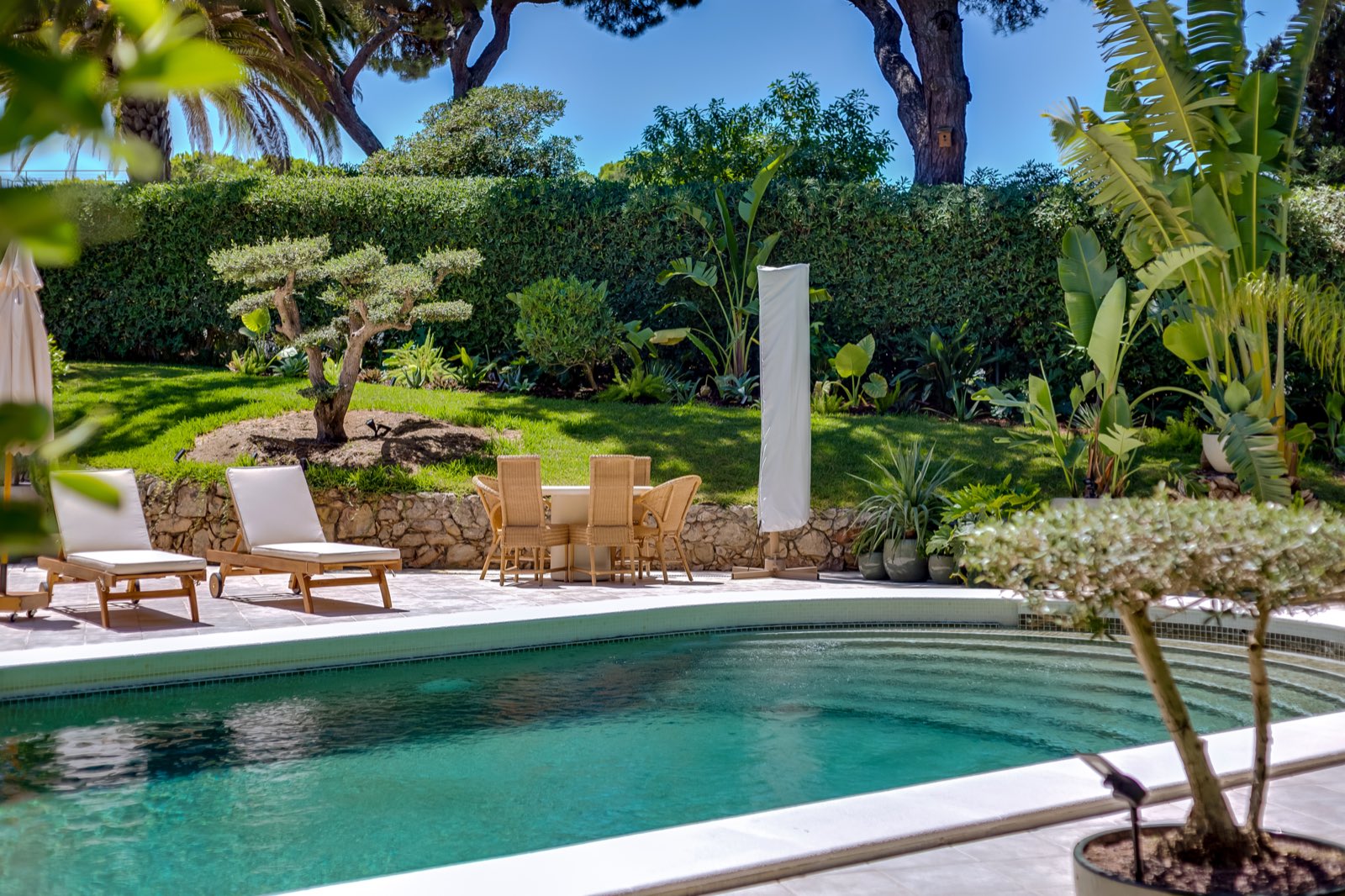 Outdoor dining table set within the villa garden