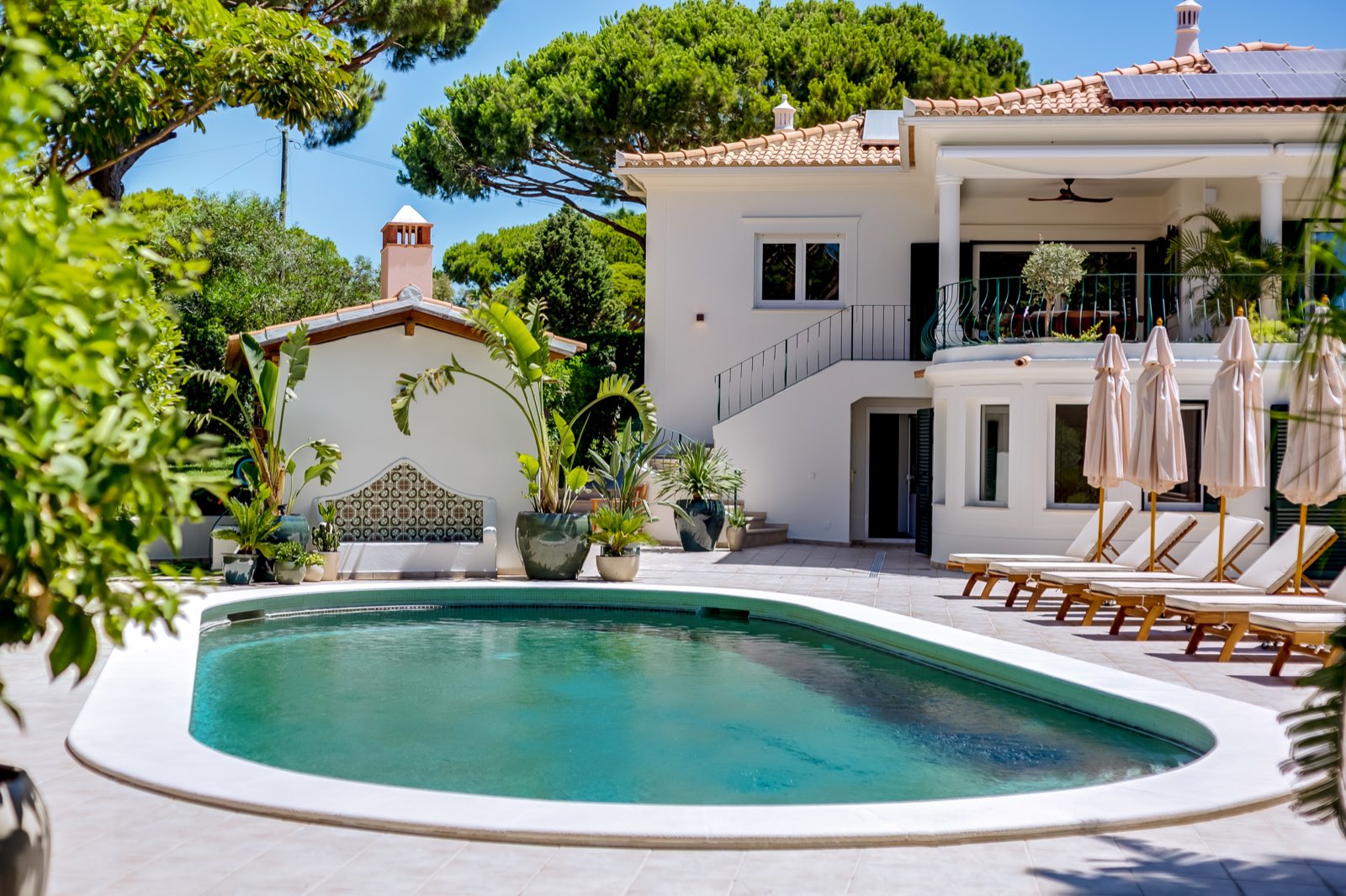 White facade of the villa with garden in the foreground