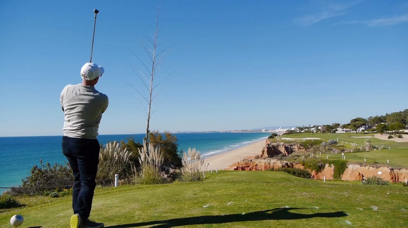 Golfer teeing off on the clifftop 16th hole of the Royal Course at Vale do Lobo